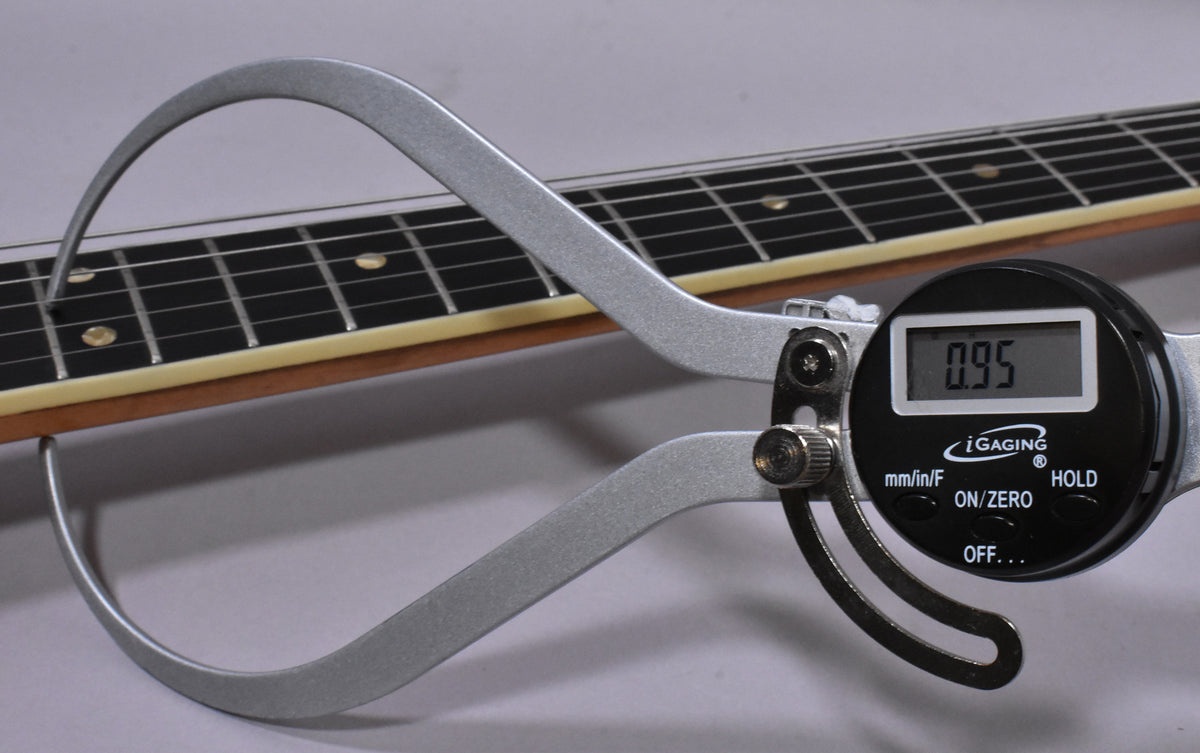 A digital caliper measures the string height at the 12th fret, showing 0.95mm above the dark rosewood fretboard.