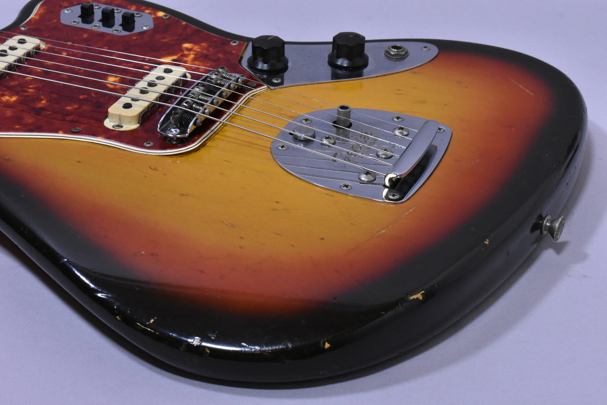 The guitar's lower body, showing a 3-tone sunburst finish with heavy wear and checking, plus a chrome vibrato system.