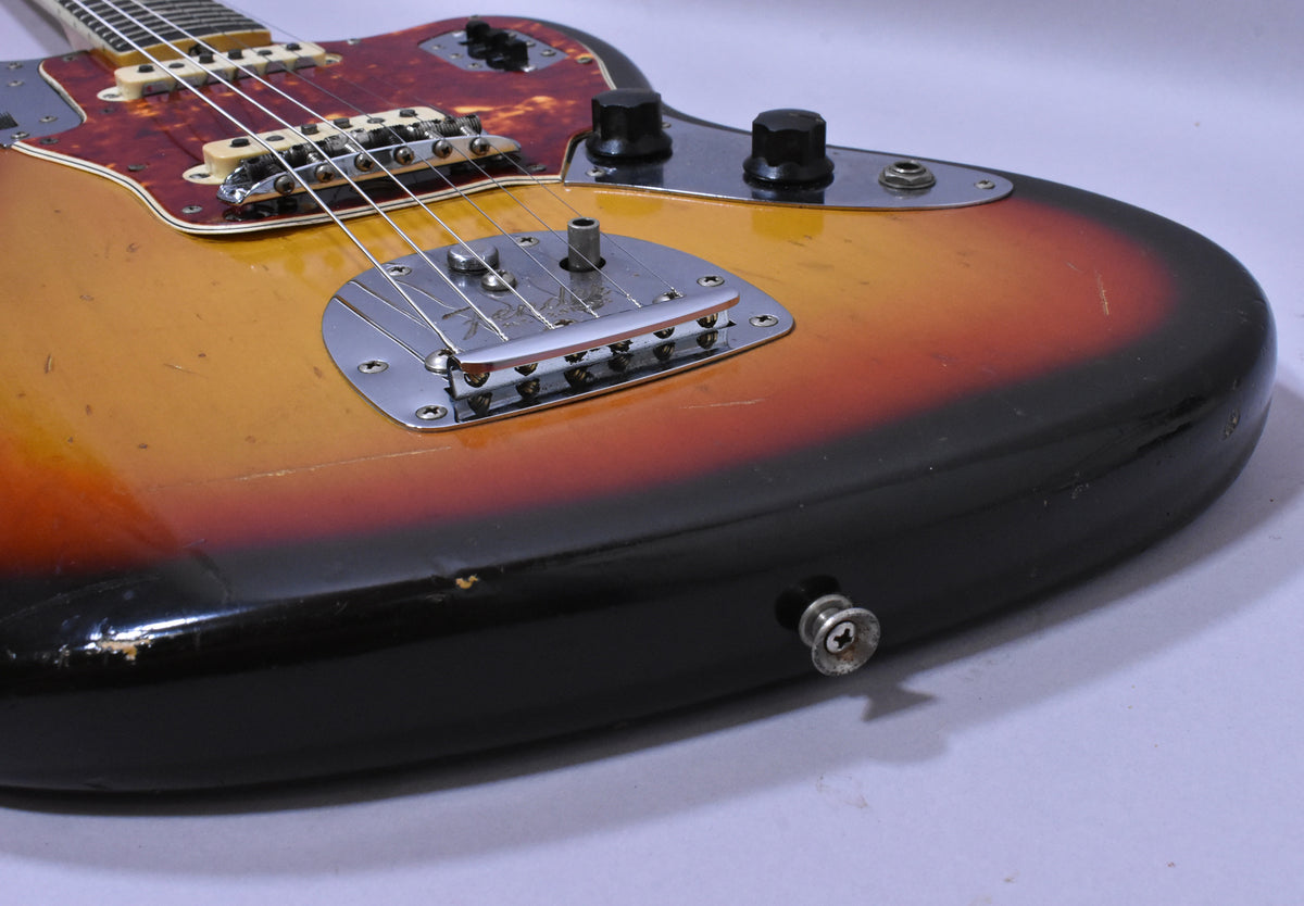 Close-up of the sunburst body, showing the bridge, tremolo, and controls, with visible wear and checking on the finish.