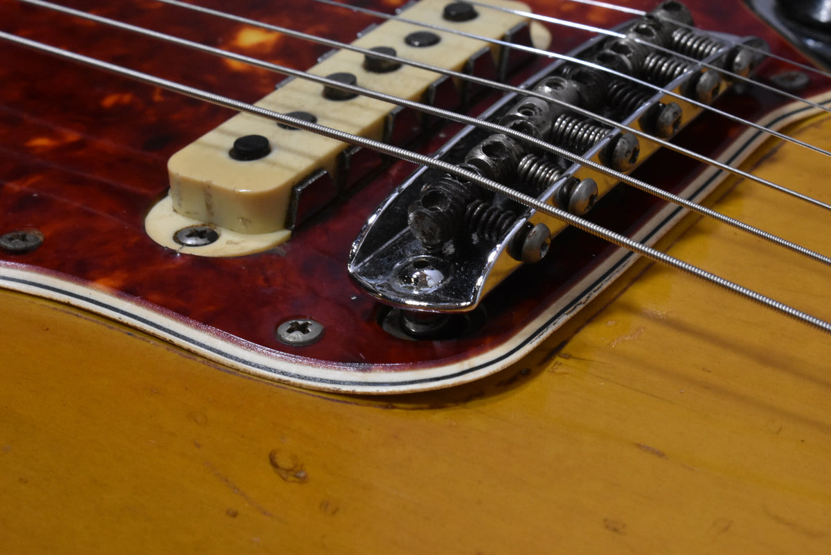 Close-up of the guitar's bridge and middle pickup, showing a tortoiseshell pickguard, chrome hardware, and light wear on the sunburst finish.
