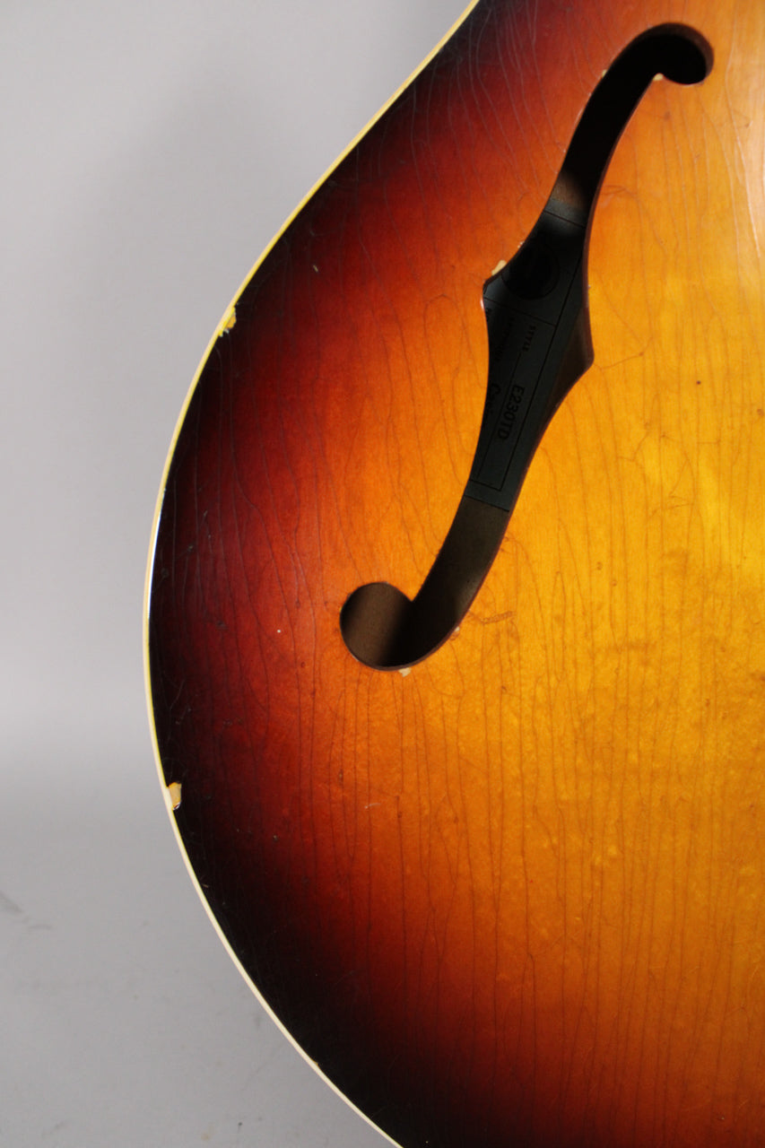 Close-up of the sunburst guitar body with an f-hole, showing extensive finish checking and binding wear along the upper curve.