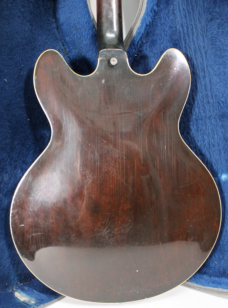 The guitar's dark sunburst back, with white binding, shows many fine scratches and some finish wear, especially near the neck joint.
