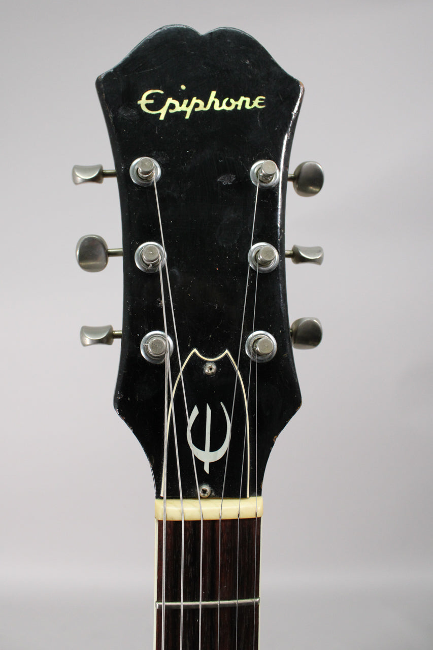 The black headstock, with six metal tuners and a mother-of-pearl "E" logo, shows light wear and finish checking.