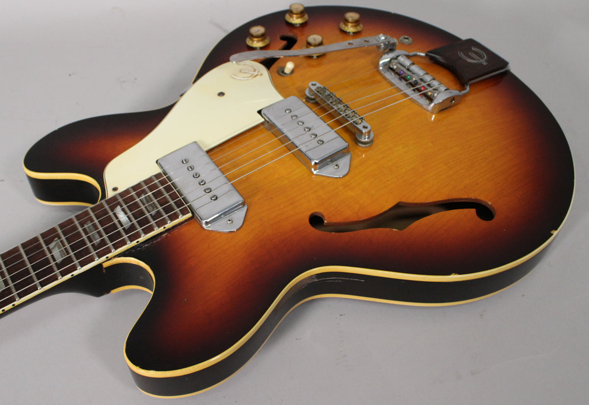 Sunburst archtop electric guitar, angled from neck to lower bout, showing two P90 pickups, vibrato tailpiece, and F-holes.