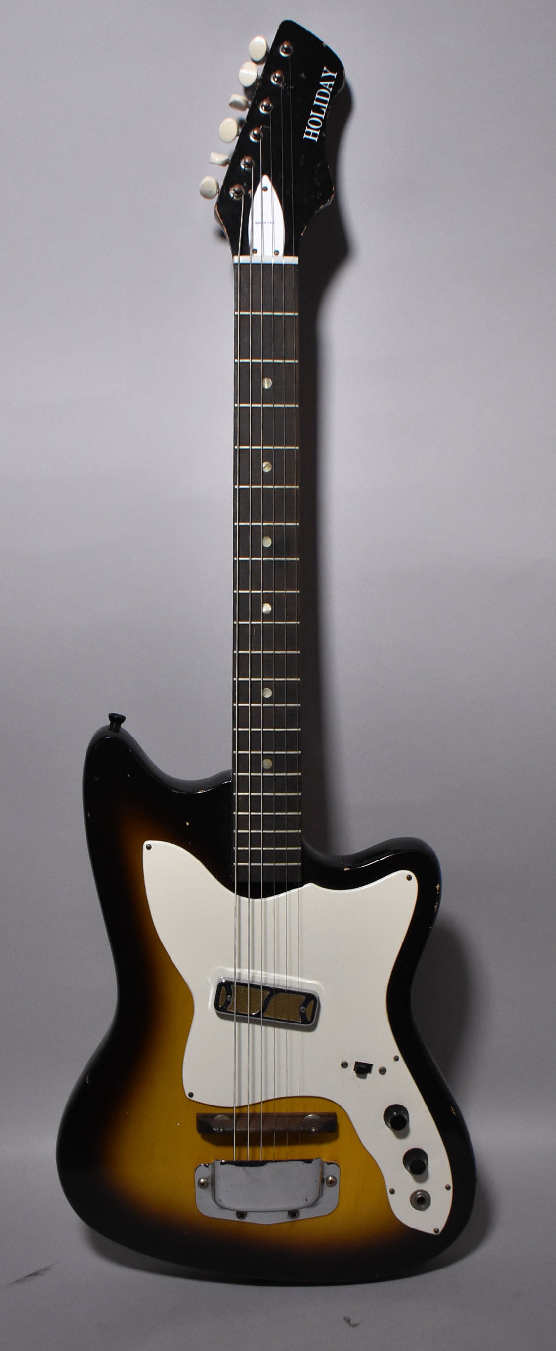 Full-length view of a sunburst electric guitar with a white pickguard, single gold foil pickup, and two control knobs.