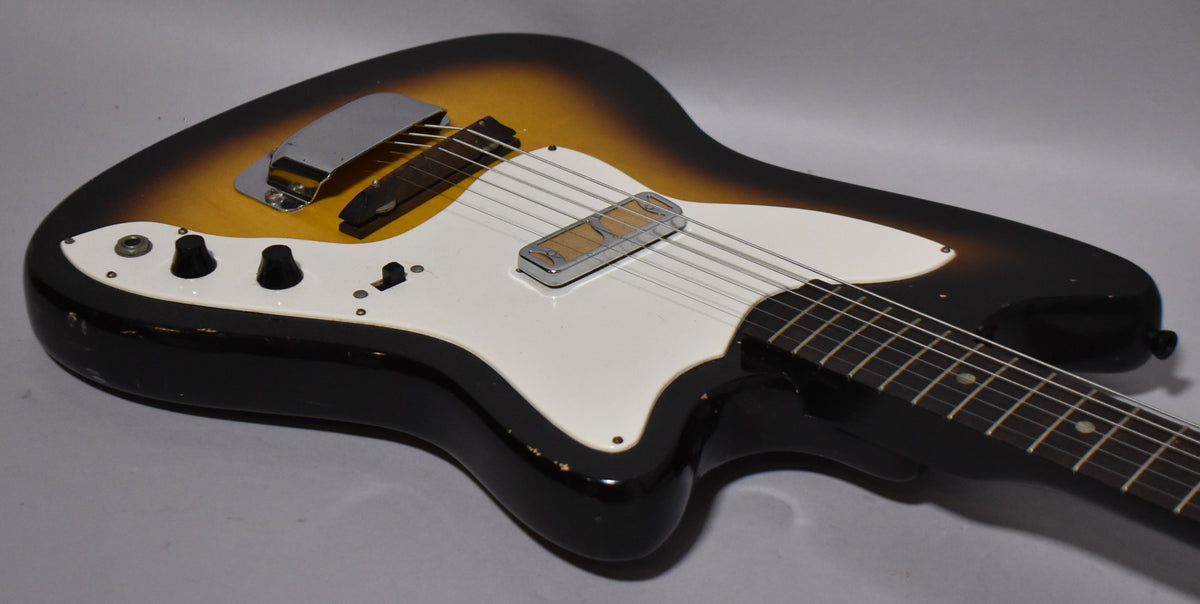 Sunburst electric guitar, angled view of body and neck, showing two black knobs, a white pickguard, and two pickups.
