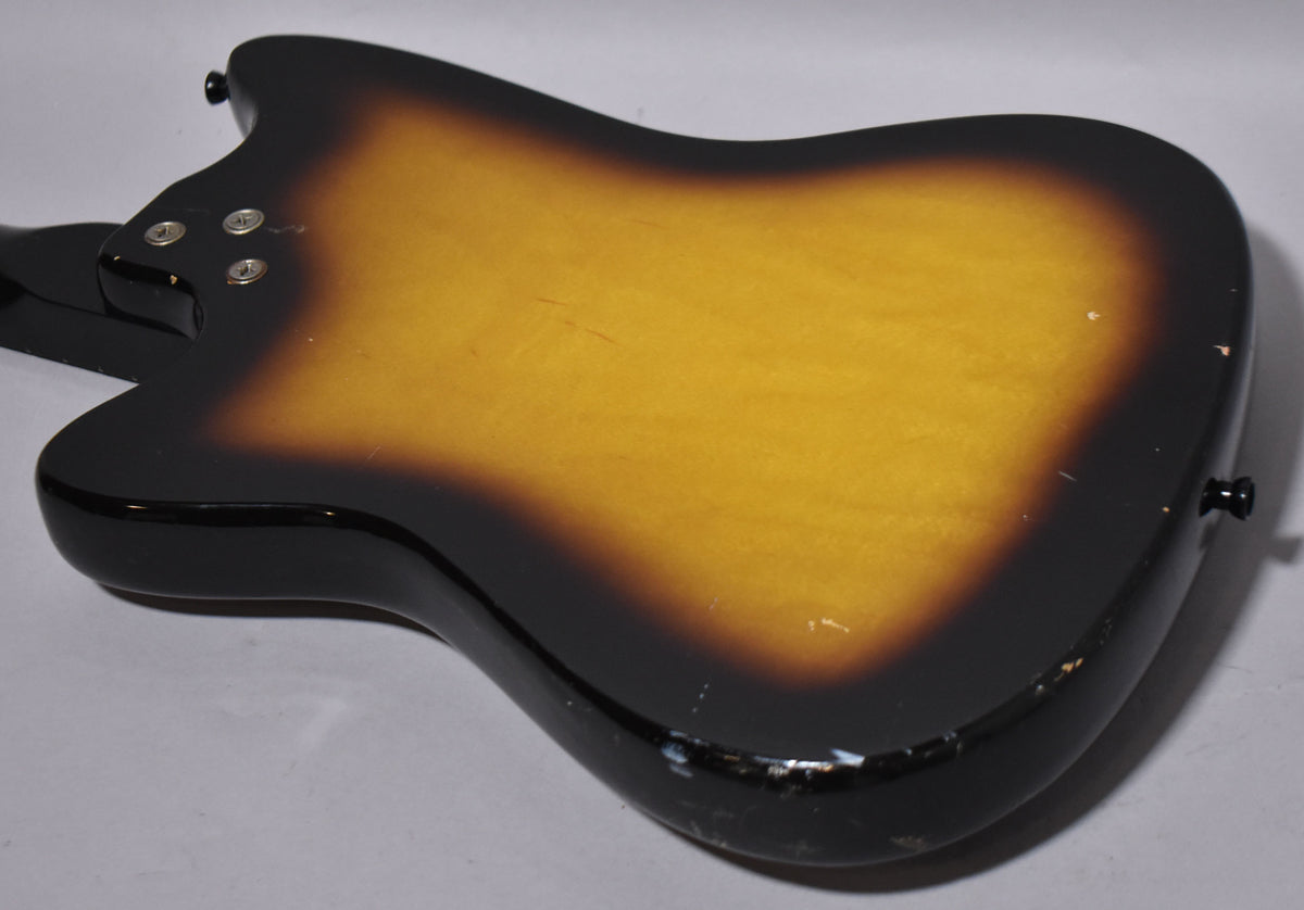 The guitar's back, a sunburst finish with a black edge and amber center, shows wear and chips along the bottom edge.