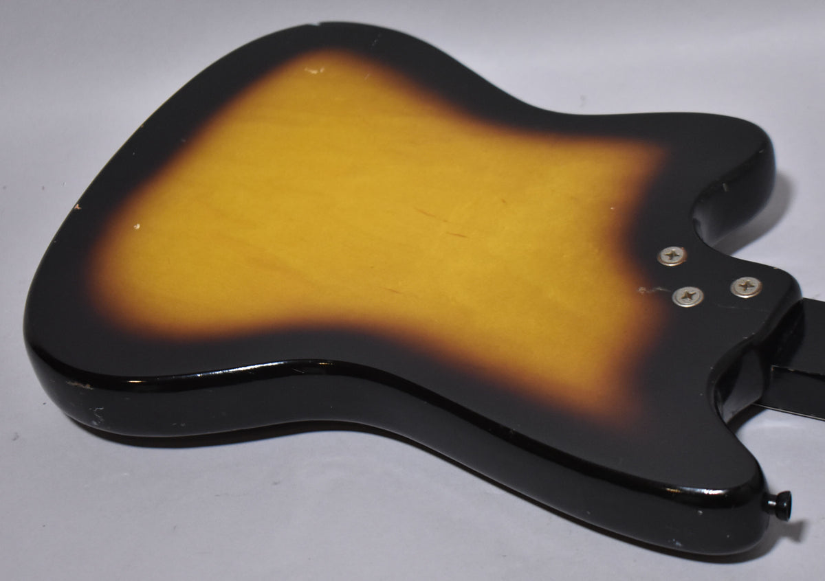 The back of the guitar body, showing a three-tone sunburst finish with visible scratches, dings, and four neck plate screws.