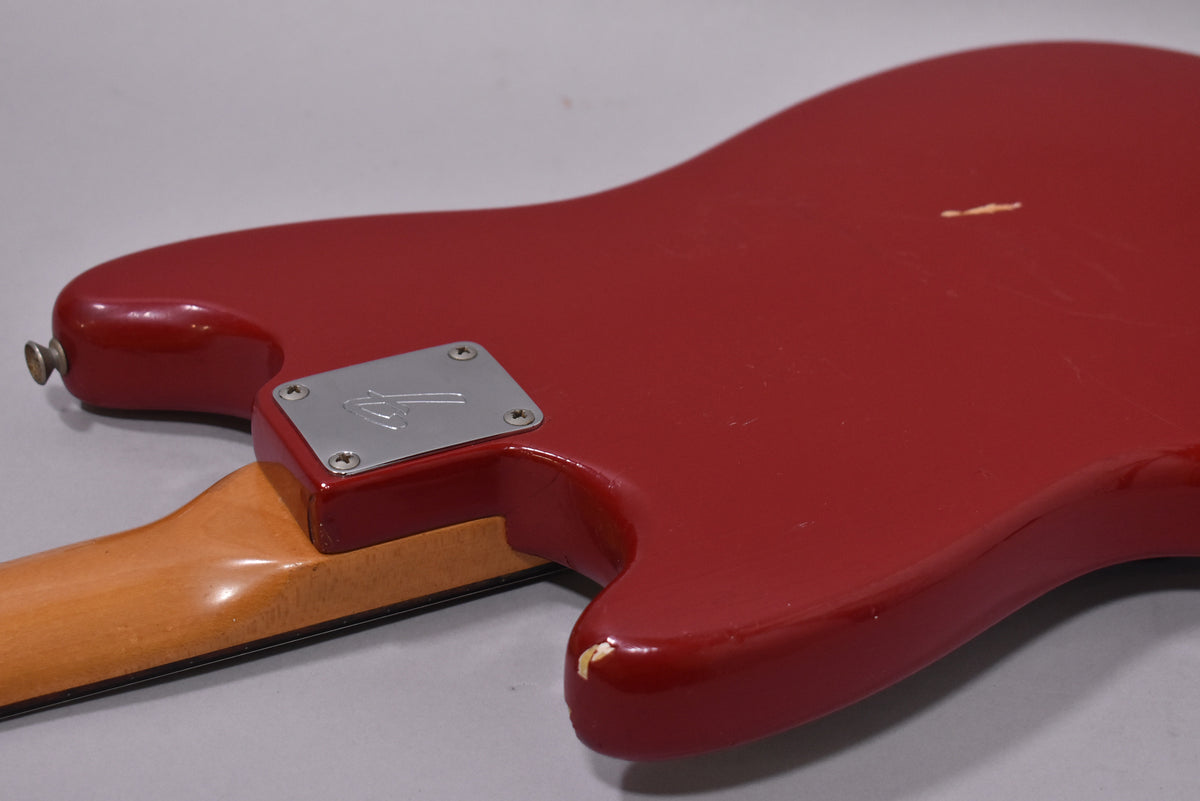Back of the Dakota Red guitar body, showing the neck plate, strap button, and a large chip on the lower horn.