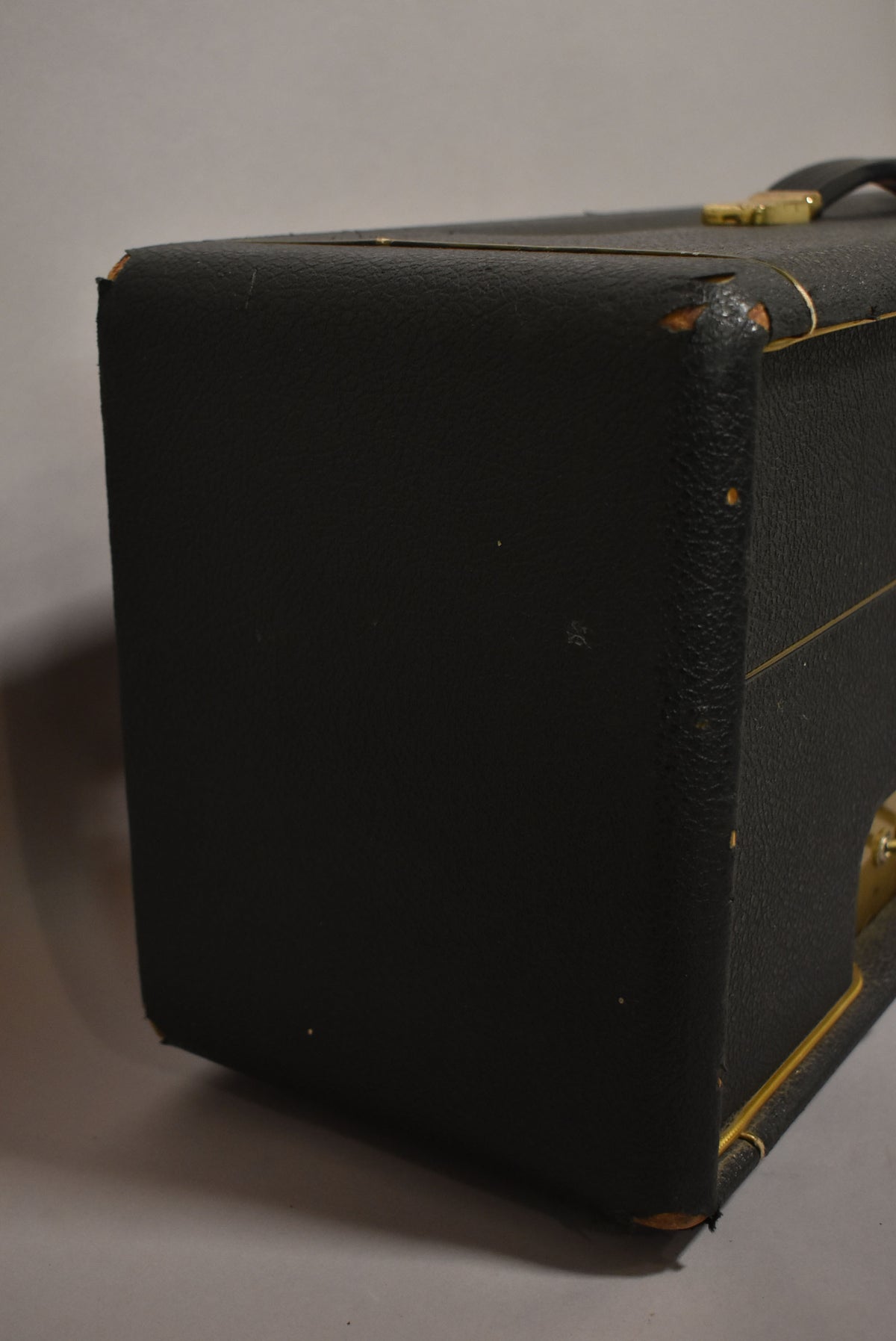 The black textured amplifier head is viewed from the left side, showing worn tolex on the top and bottom left corners.