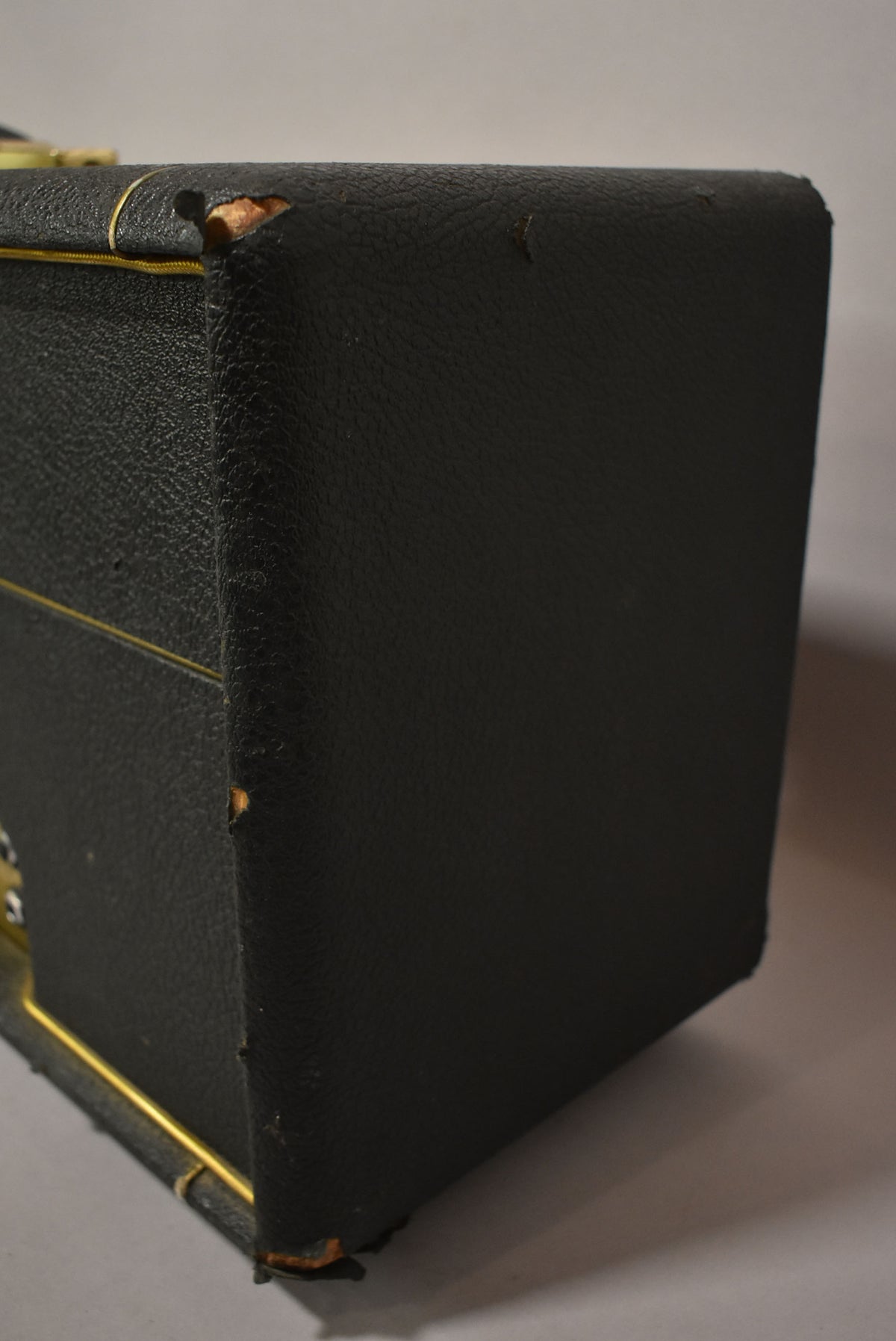 The black textured amplifier head is shown from the right side, with tears in the tolex exposing wood on the top and bottom edges.