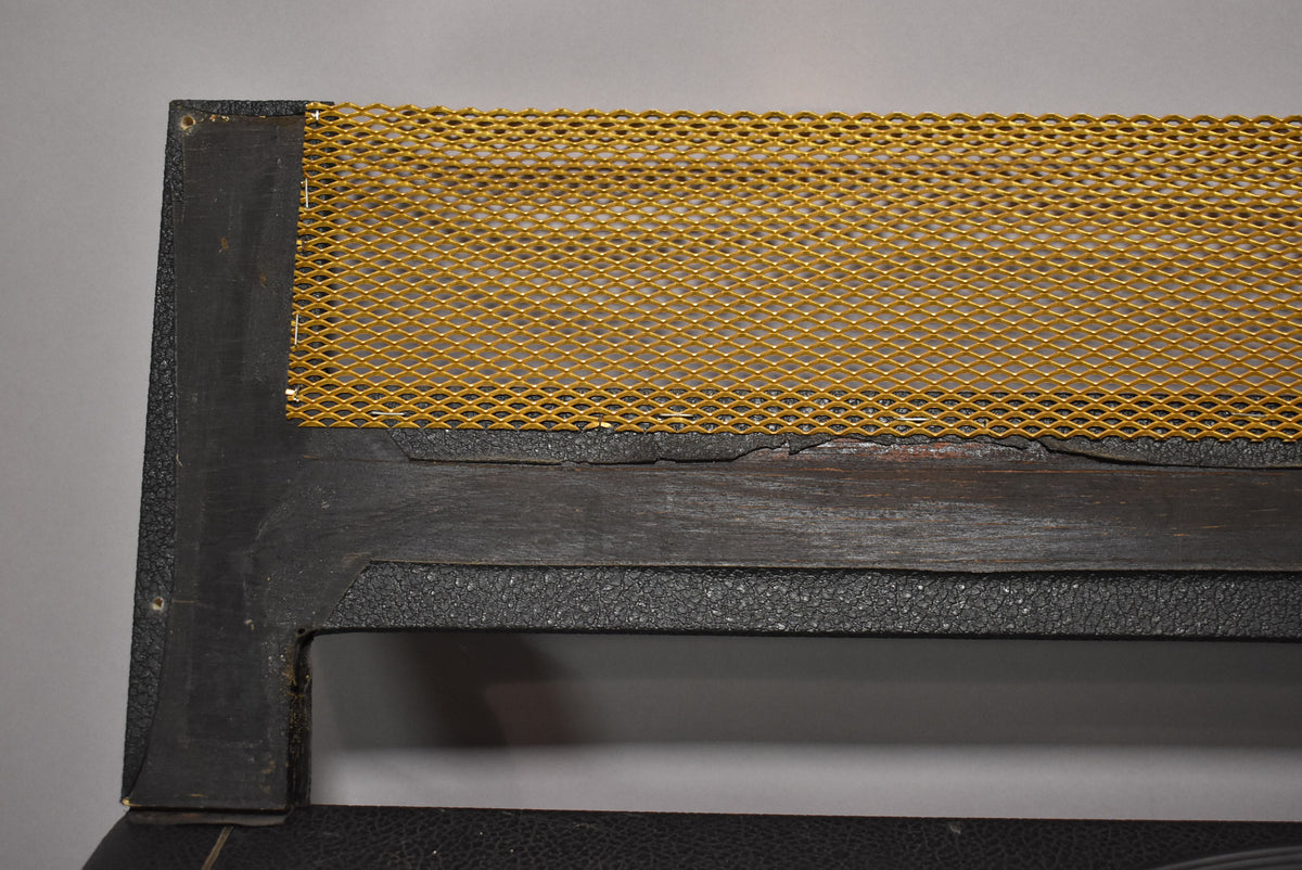 A close-up of the amp's top edge shows a gold diamond mesh grille and a black textured vinyl covering with visible wear and cracking.