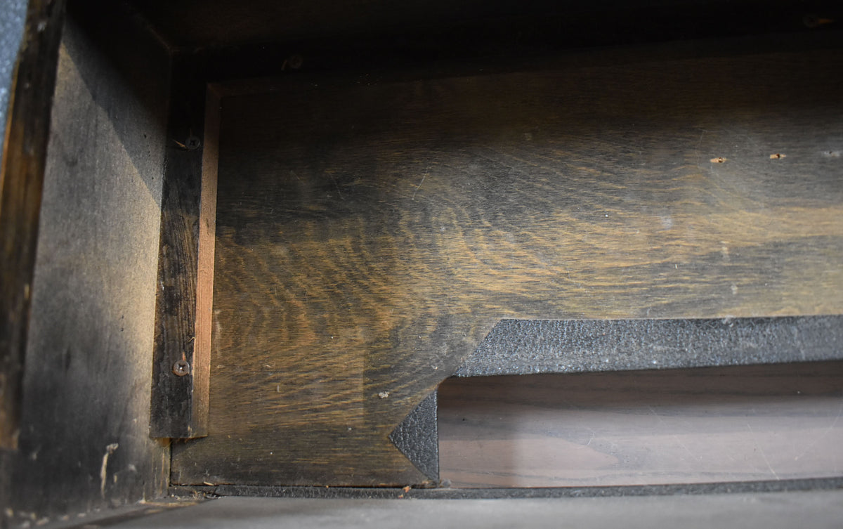 Top-down view of the amp's dark wood interior, showing grain, a corner brace, and a cutout, with visible dust and wear.