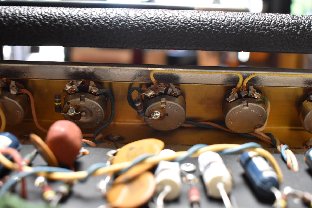 A close-up of the amp's internal components, showing three large, round potentiometers with wires soldered to their terminals.
