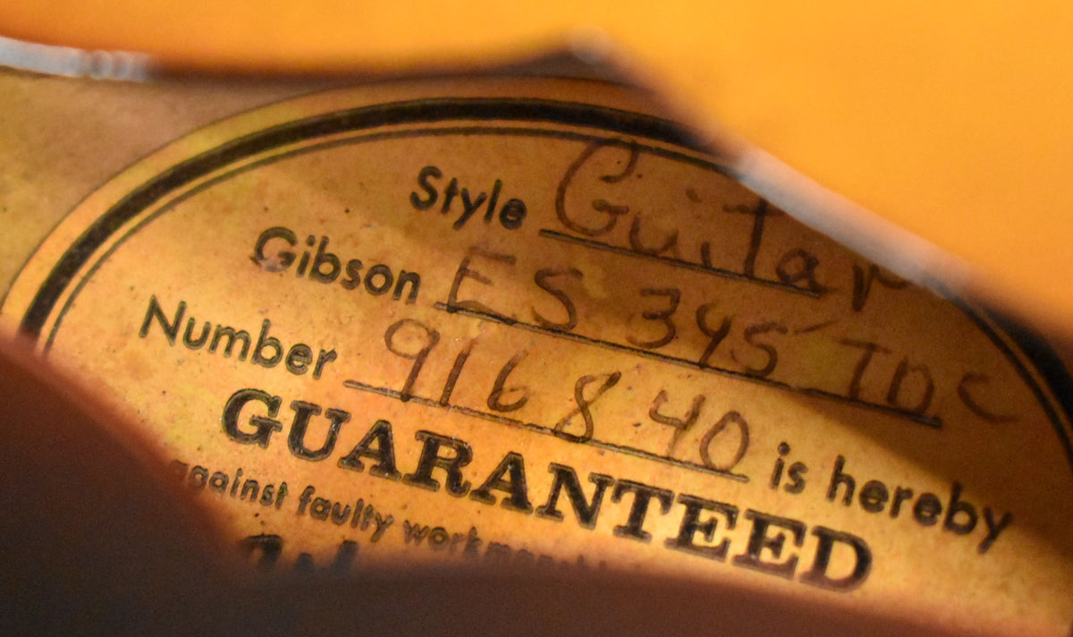 A close-up of the guitar's orange interior label, showing handwritten "ES 345 TDC" and "916840" on a faded, textured surface.