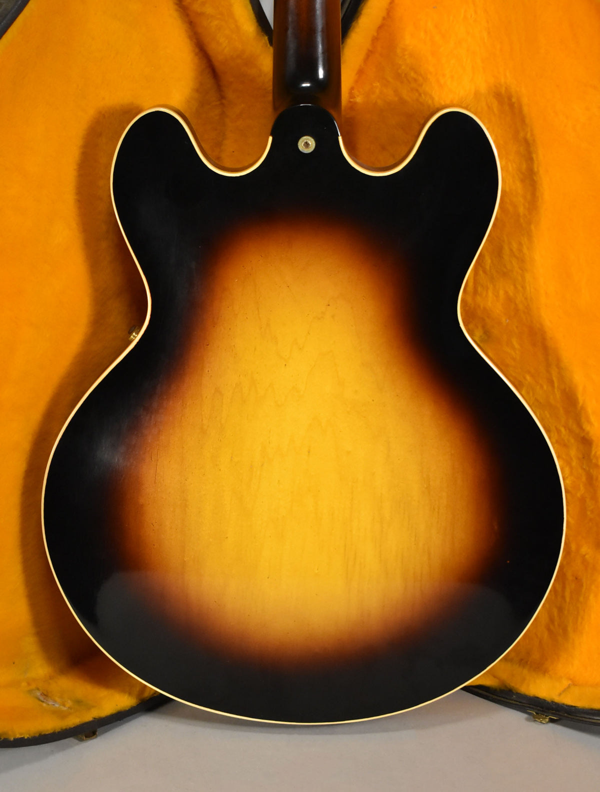 Full rear view of the sunburst semi-hollowbody guitar, showing the dark brown edges fading to a lighter brown center.
