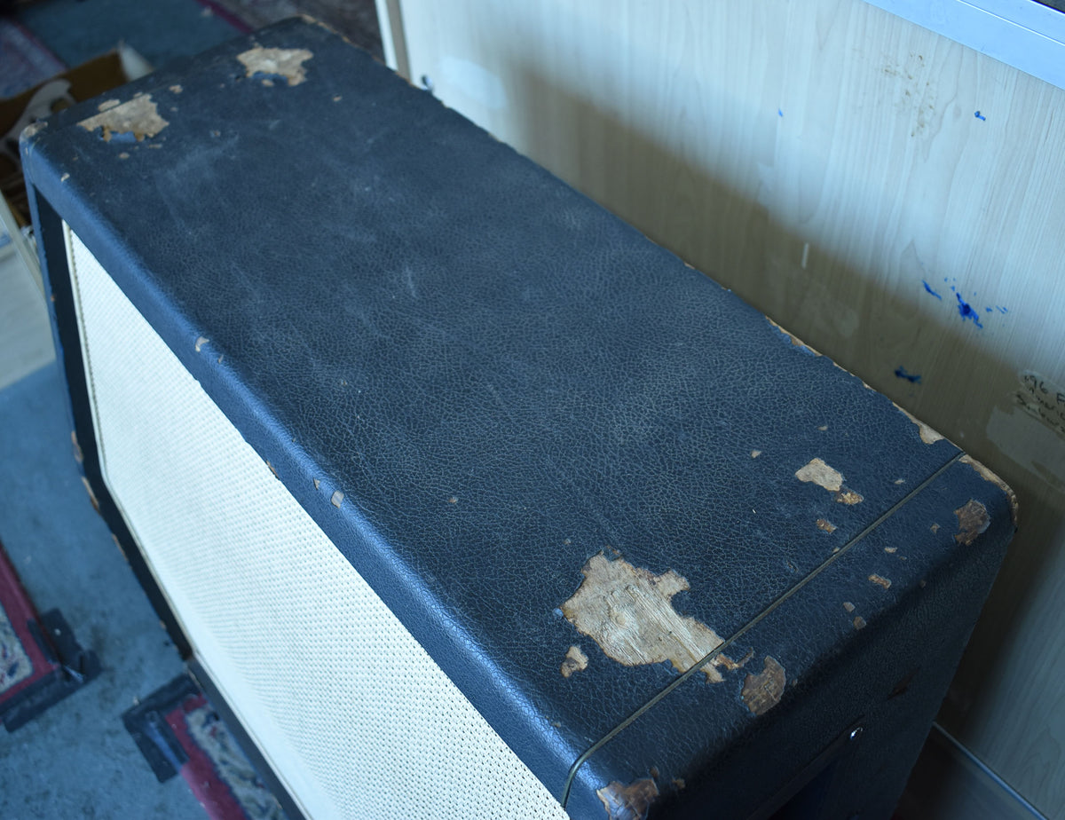 Top-down view of the black basketweave cabinet, showing significant wear and peeling of the tolex on the top and corners.