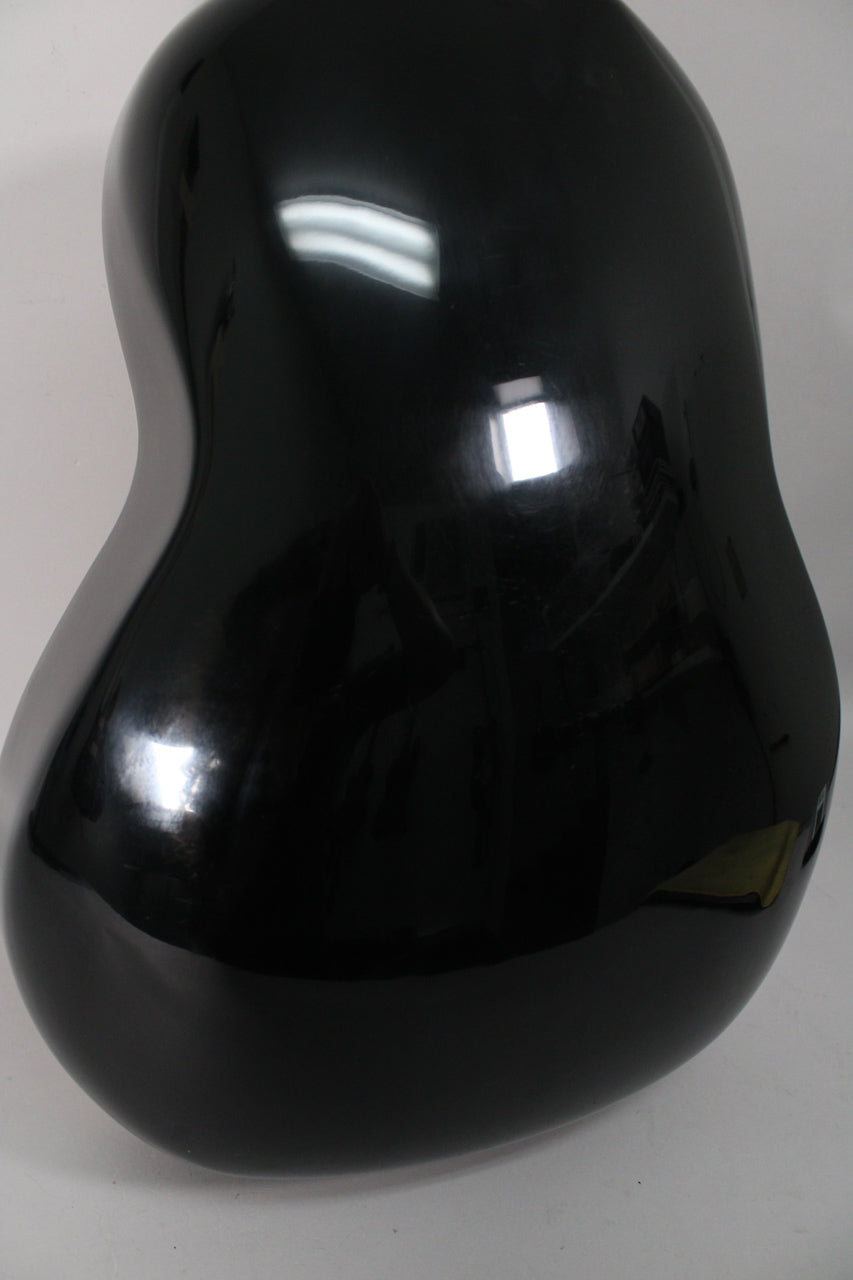 Close-up of the guitar's black, shiny, bowl-shaped back, showing light reflections and minor surface wear.