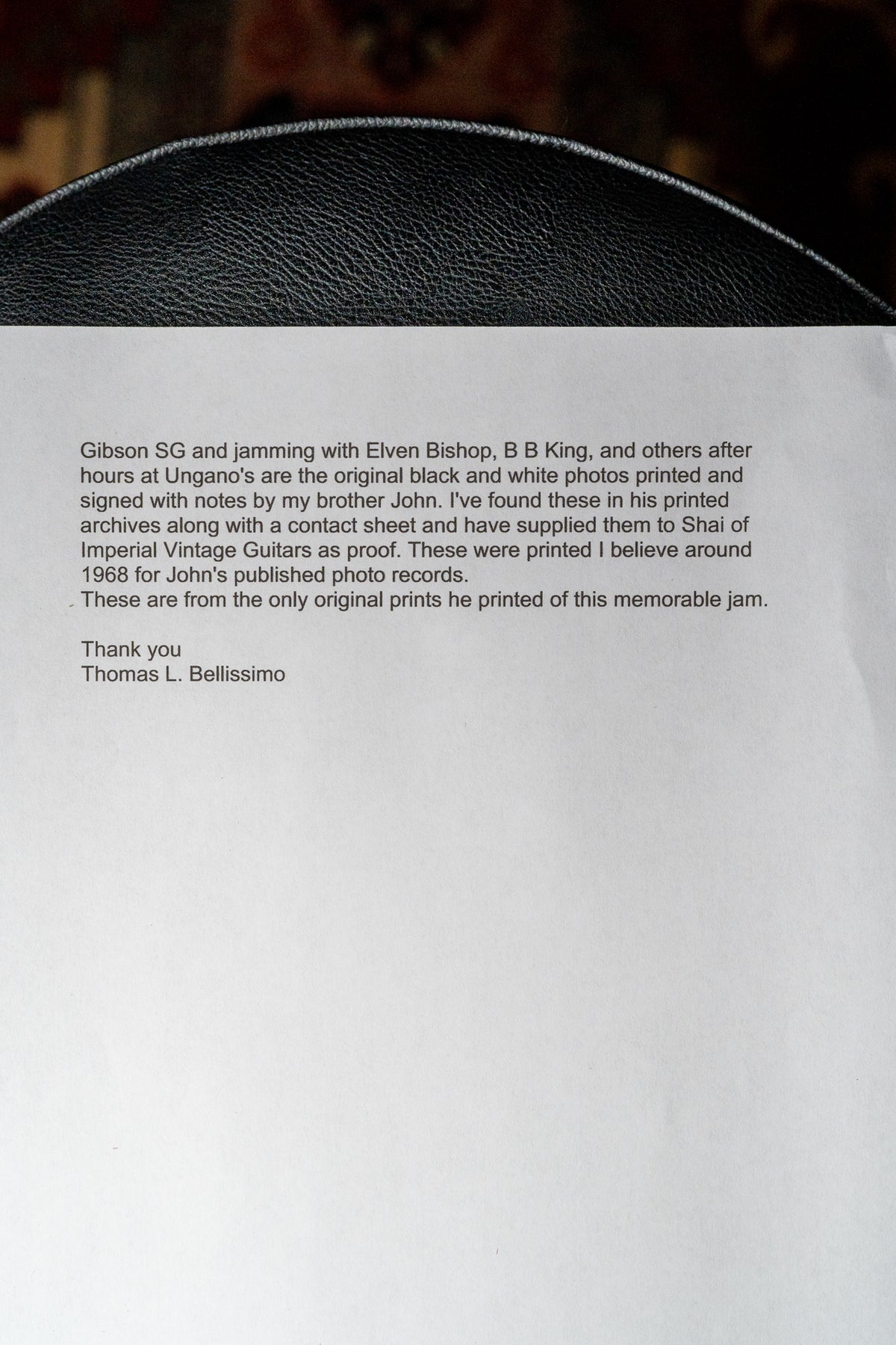 A white sheet of paper with black text, partially obscured by a black textured surface at the top.