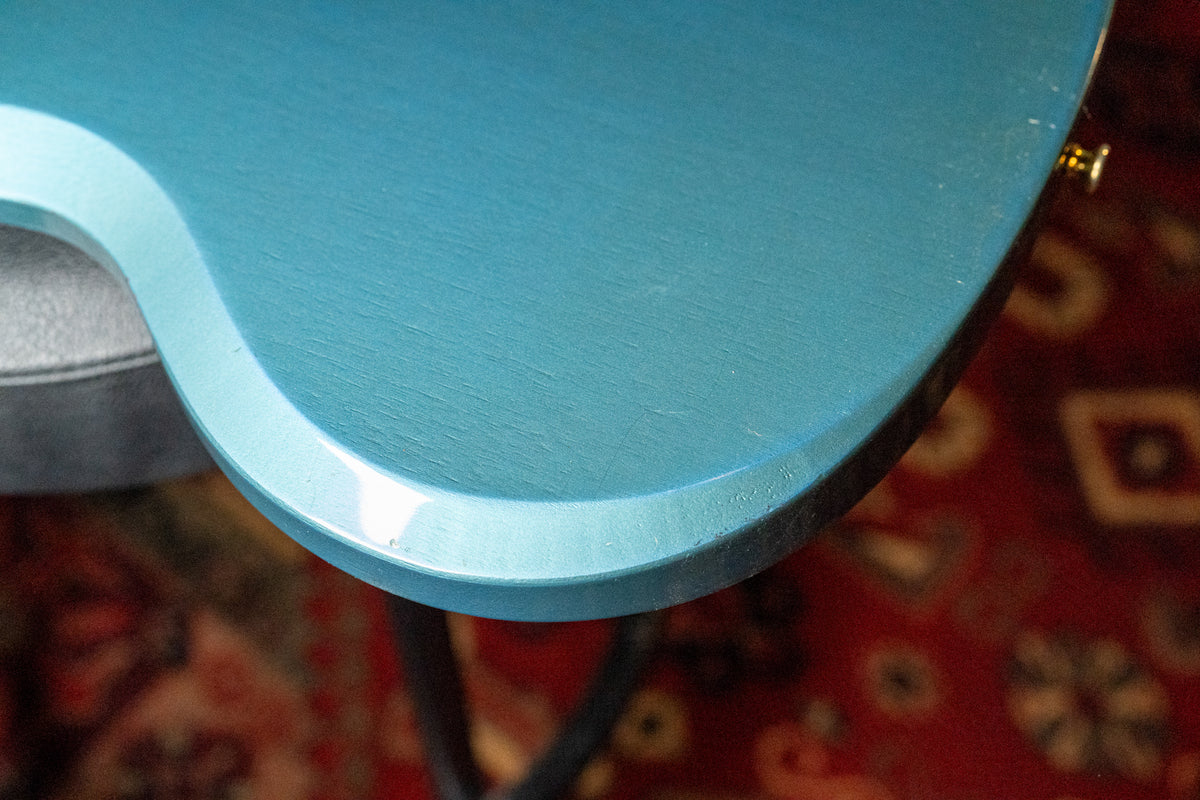 Close-up of the guitar's upper body in Pelham Blue, showing light wear and wood grain through the matte finish, with a glossy edge.