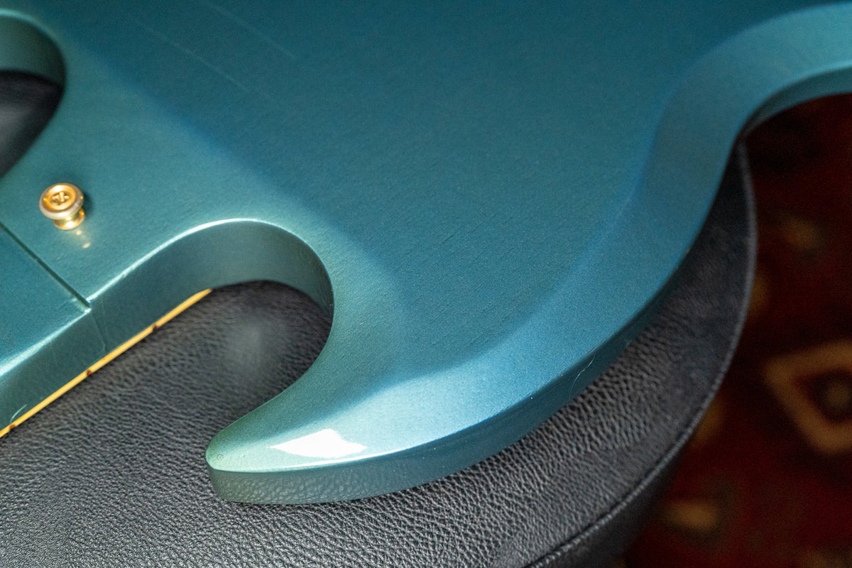 Close-up of the guitar's lower horn in metallic Pelham Blue, showing light wear and a gold strap button.
