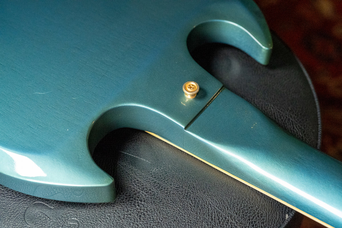 Close-up of the guitar's back, showing the neck joint and upper horn in Pelham Blue with light wear and a gold strap button.