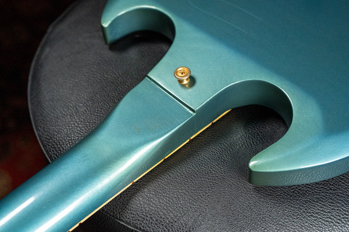 Close-up of the guitar's upper body and neck heel in Pelham Blue, showing a strap button and light finish wear.