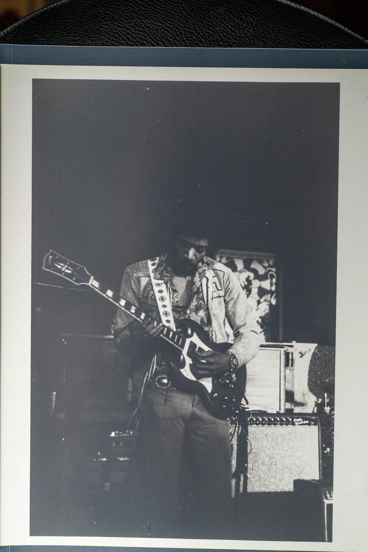 Black and white photo of Jimi Hendrix playing a dark SG Custom, angled left, with a white pickguard and three pickups.