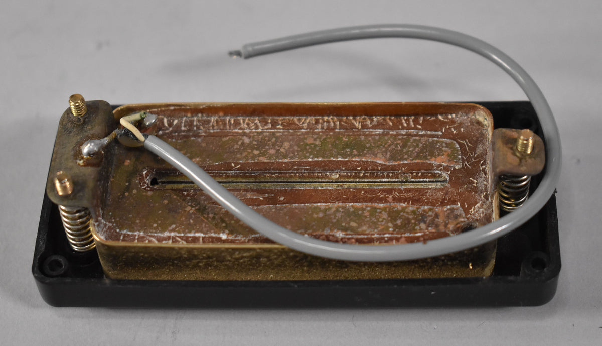 The pickup's brass baseplate is heavily oxidized with white residue, showing a grey wire with a broken end.