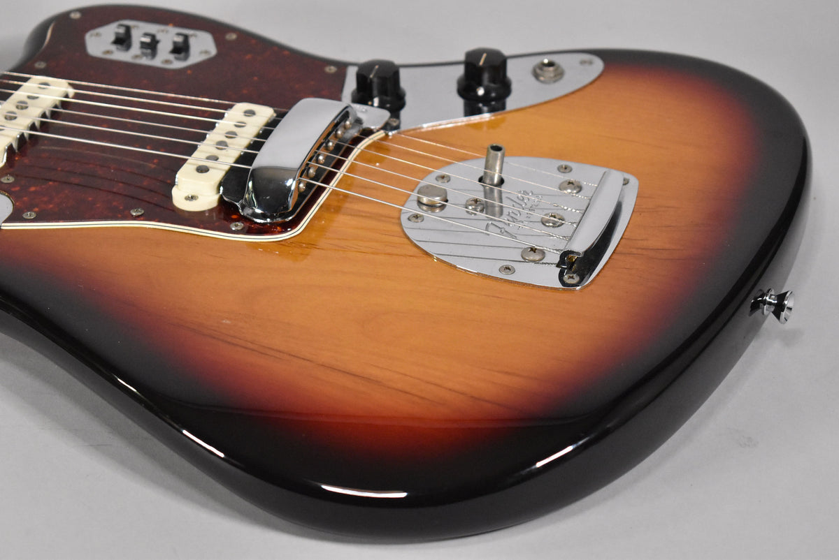 Close-up of the guitar's lower body, showing the sunburst finish, tortoise pickguard, chrome bridge, and control knobs.