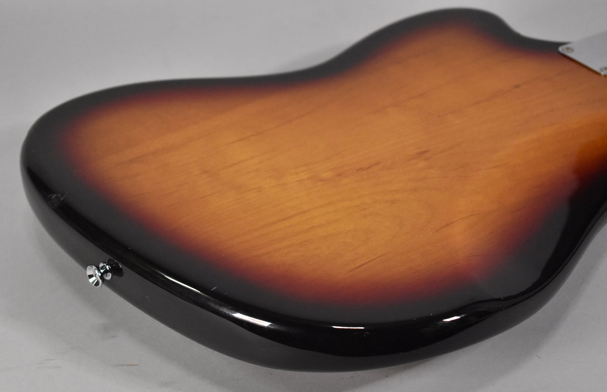 The guitar's back, in 3-tone sunburst, shows light surface scratches and a chrome strap button on the lower bout.