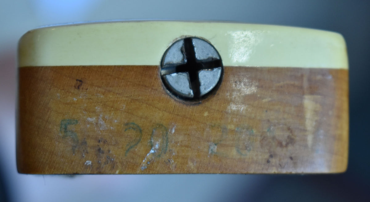Close-up of the neck heel, showing the light wood with faded green numbers and a large Phillips head screw.