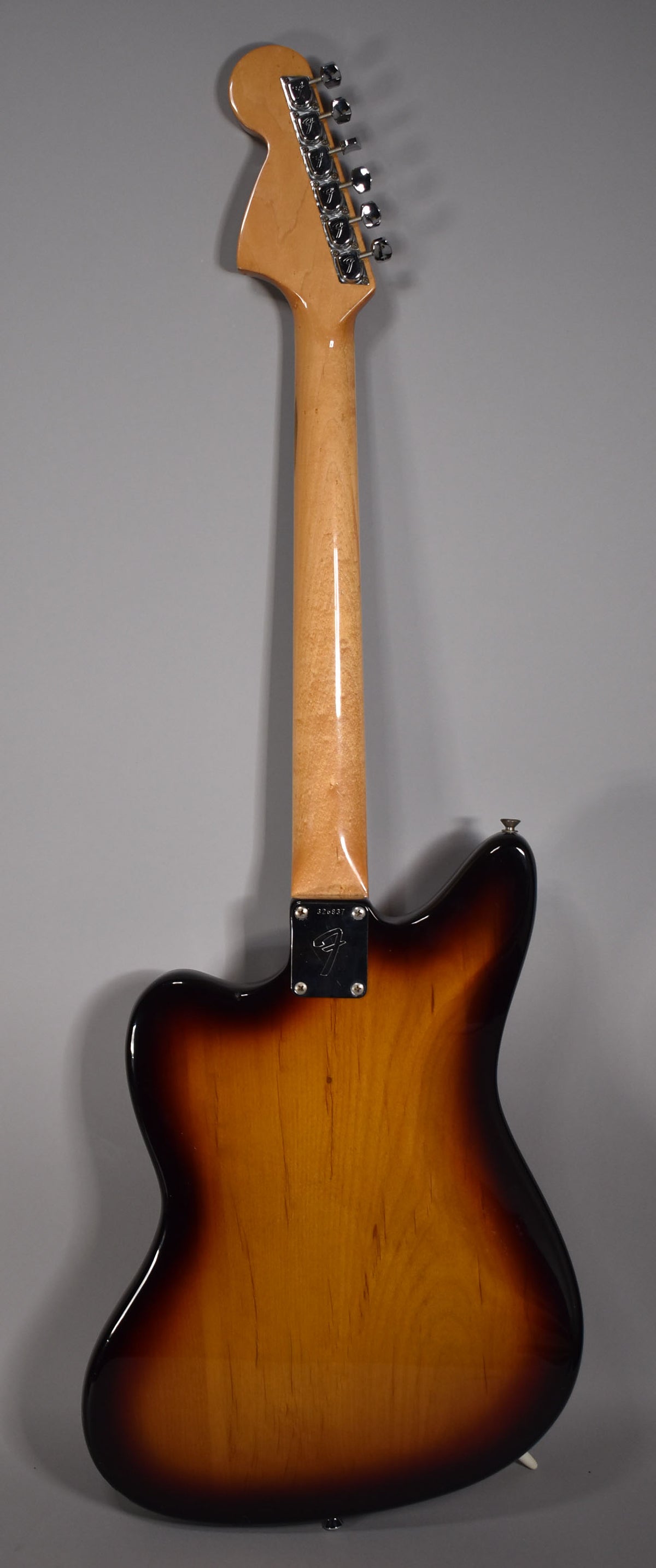 Full rear view of the sunburst guitar, showing the maple neck, headstock with six chrome tuners, and neck plate with a serial number.