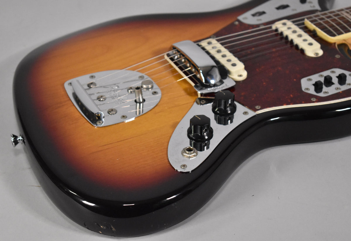 Close-up of the sunburst body, showing the vibrato tailpiece, bridge, cream pickups, tortoise pickguard, and control knobs.