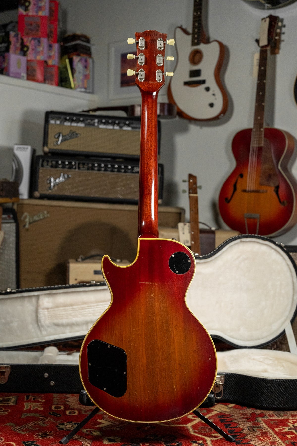 Full rear view of a cherry sunburst guitar, showing the headstock with six tuners, neck, and body with two control plates and binding.