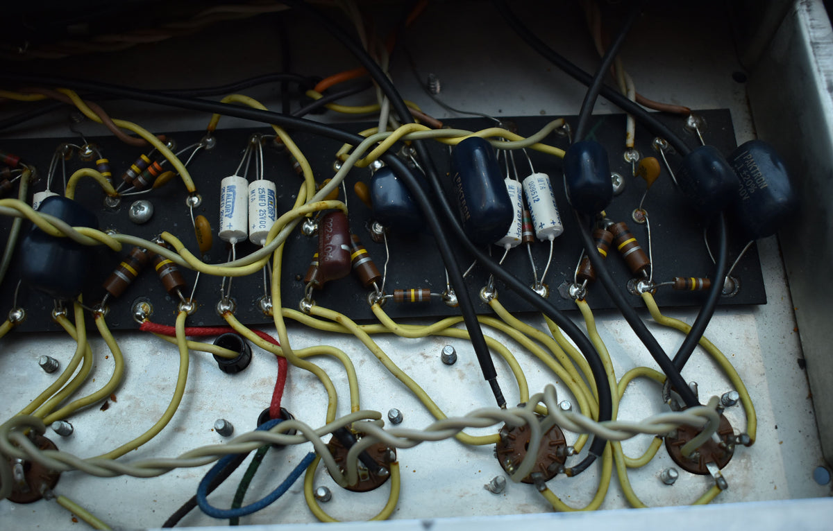 Close-up of the amplifier's internal wiring, showing a circuit board with various resistors, capacitors, and colorful wires.