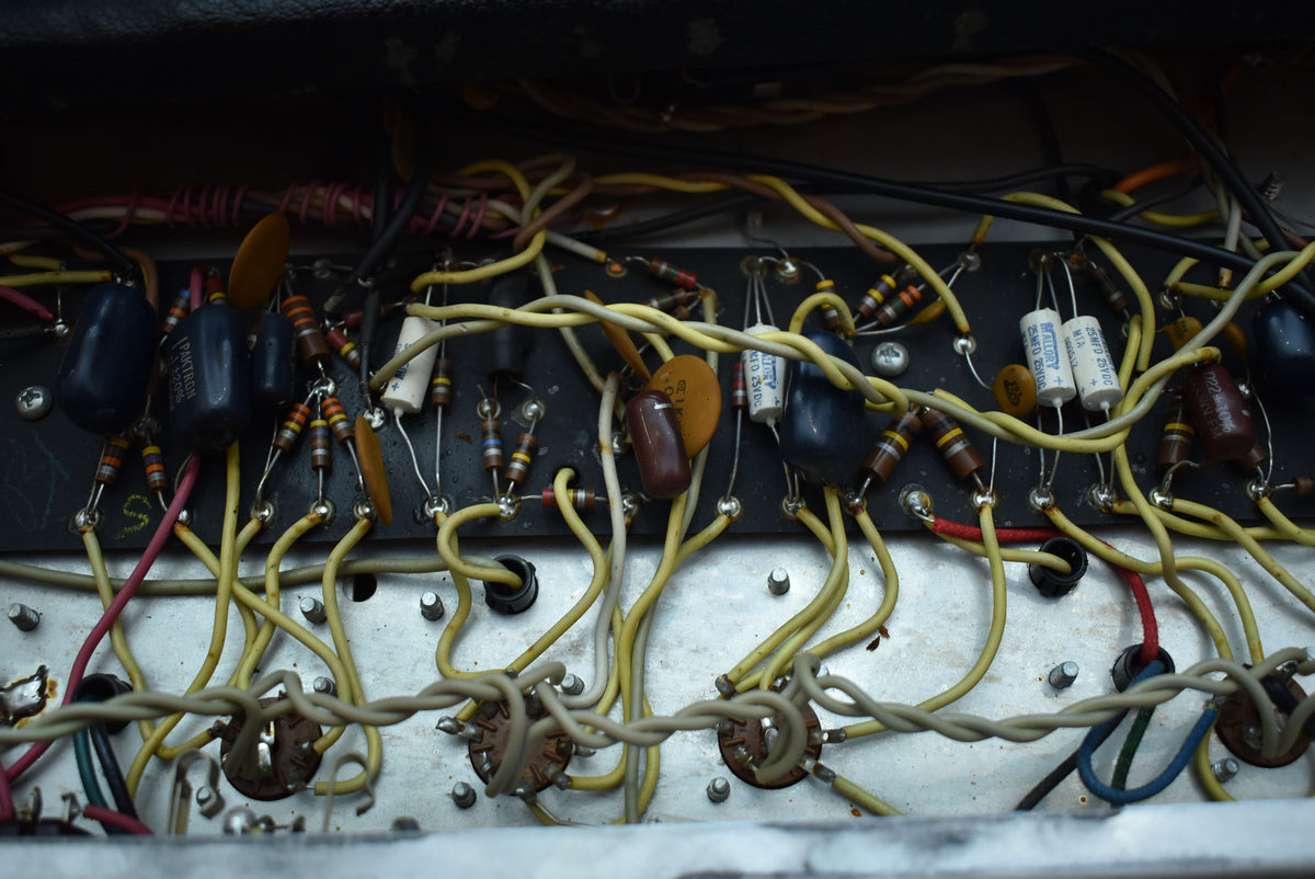 Close-up of the amplifier's internal wiring, showing a dense network of colorful wires, resistors, and capacitors on a dark board.