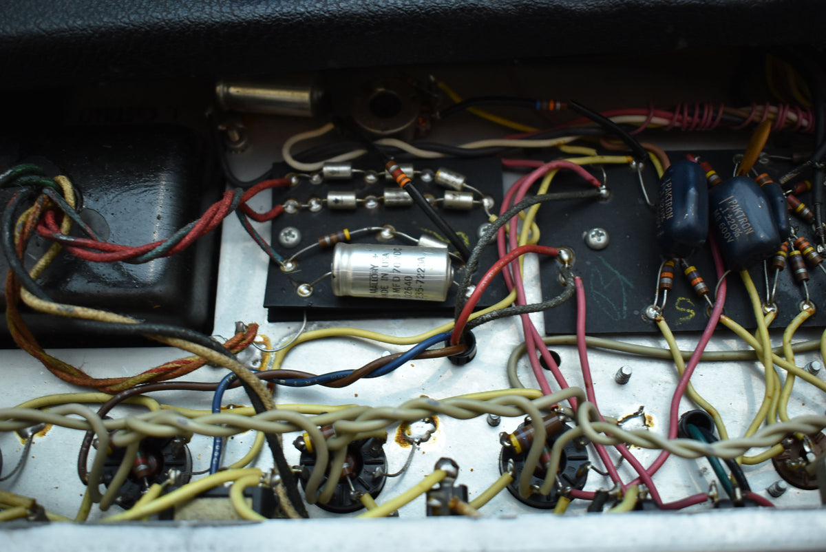 A close-up of the amplifier's internal wiring, showing a dense network of colorful wires, resistors, and capacitors on a silver chassis.