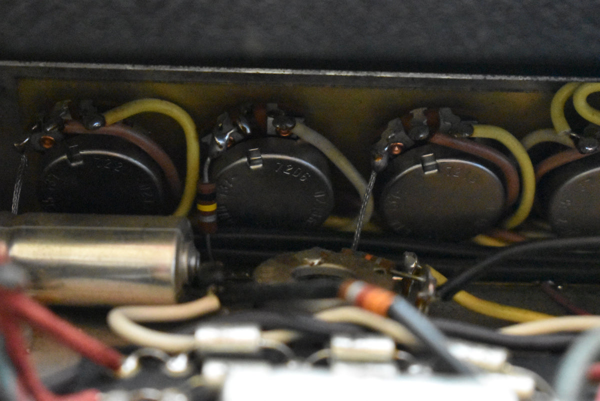 Close-up of the amplifier's internal wiring, showing several silver-colored potentiometers with various colored wires soldered to them.