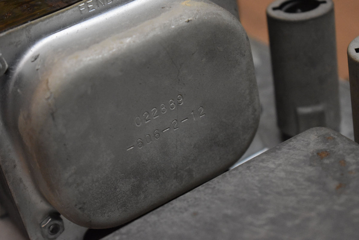 Close-up of the amplifier's silver-grey metal chassis, showing stamped numbers "022889" and "-606-2-12" with some rust spots.