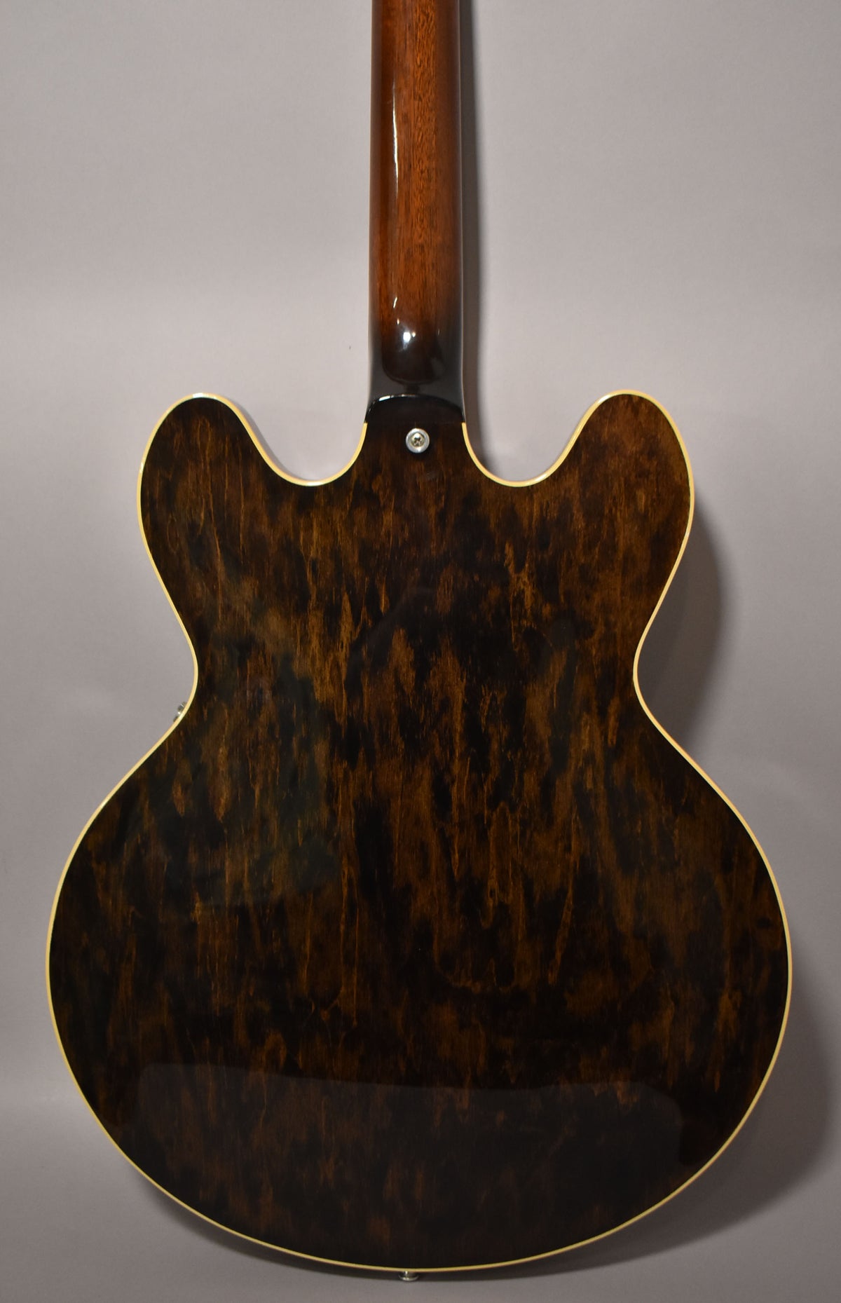 The guitar's dark walnut back and neck are shown, with a visible wood grain and light binding around the body.