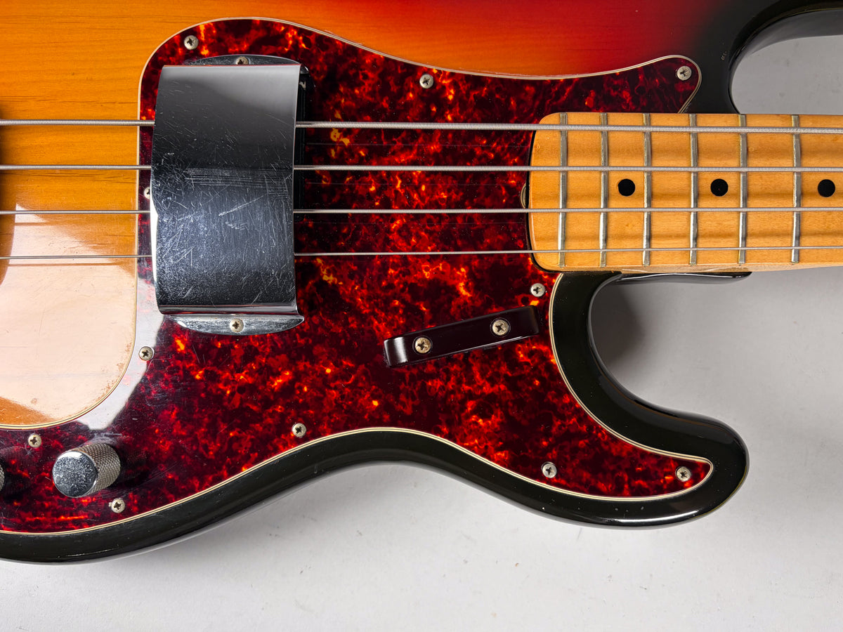 Close-up of the sunburst body, showing the tortoiseshell pickguard, chrome pickup cover with scratches, and maple fretboard.
