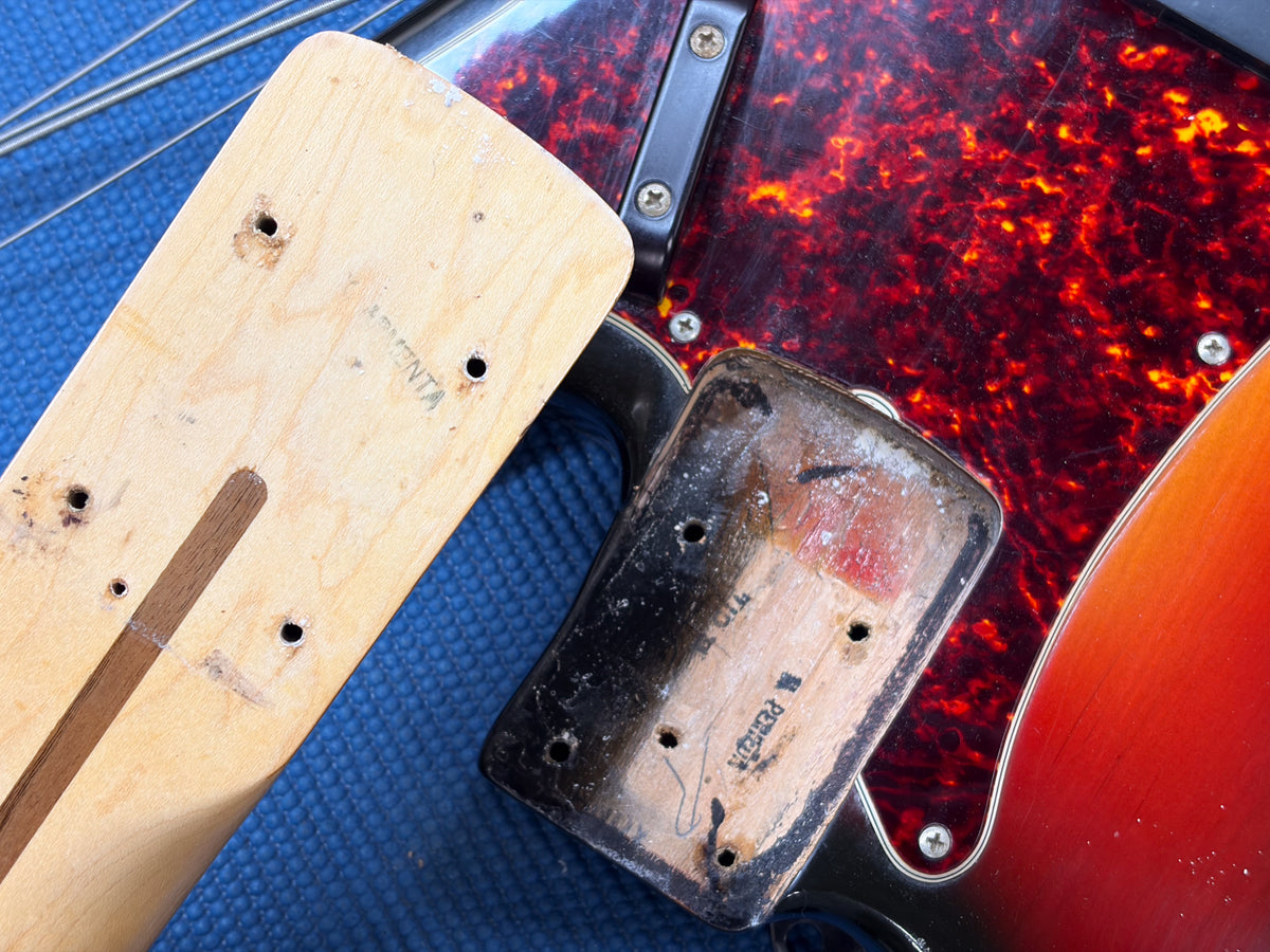 Close-up of the sunburst body and tortoise pickguard, with the neck removed showing the heel and neck pocket.