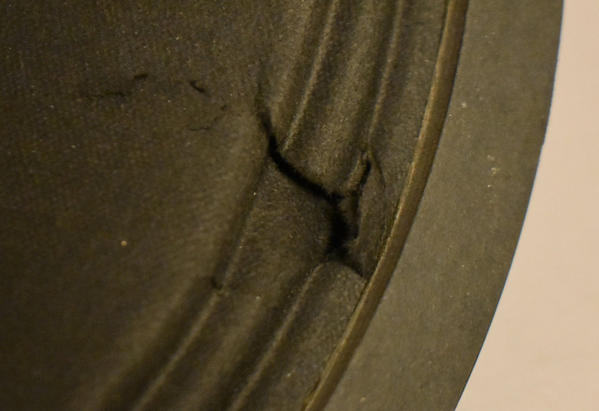 Close-up of the dark gray speaker cone and surround, showing a tear in the cone and visible wear on the surround.