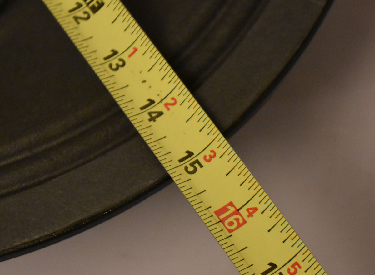 A yellow tape measure diagonally crosses a dark gray speaker frame, showing 12 to 16 inches.