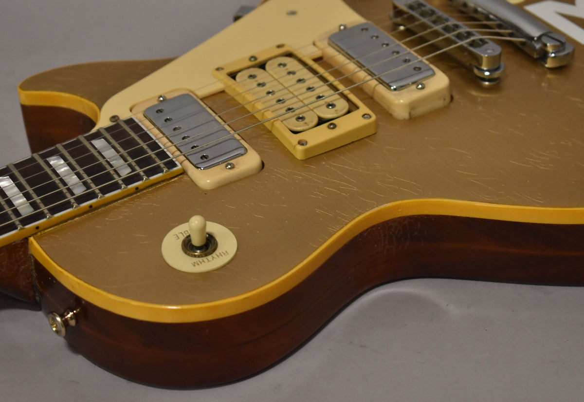 Close-up of the goldtop body, showing aged cream mini-humbuckers, pickup rings, and toggle switch, with heavy finish checking.
