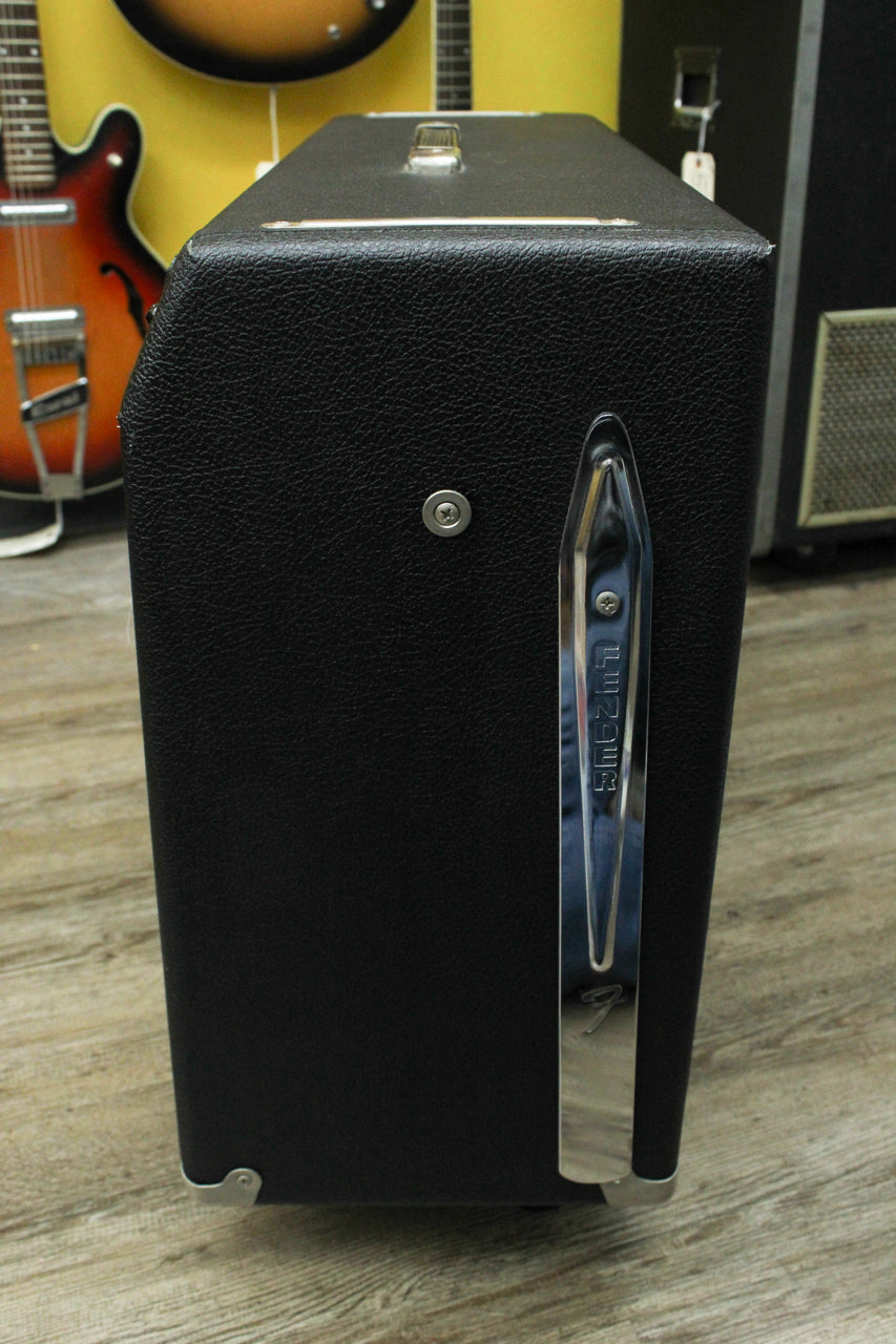 The black Tolex amp is viewed from the right side, showing a chrome tilt-back leg, a top handle, and metal corner protectors.