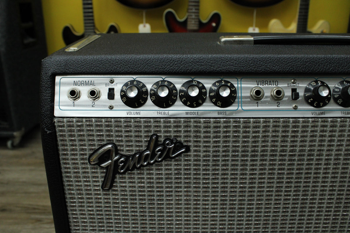 Close-up of the amp's silverface control panel with black knobs, inputs for Normal and Vibrato channels, and a silver grille cloth.