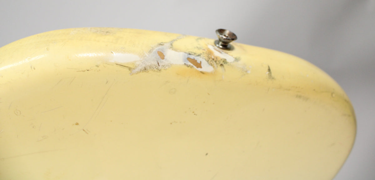 Close-up of the bass's upper horn, showing heavy paint chipping and wear around the strap button.