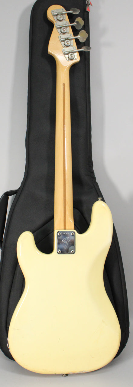 The back of an Olympic White bass with a maple neck and chrome tuners, showing some wear and scratches on the body.